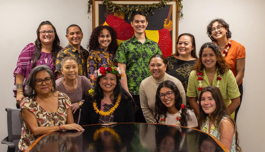 Large group of people wearing colorful leis posing indoors