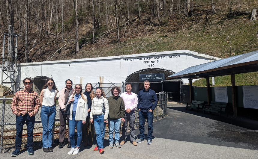 Group of people posing outside a mining building