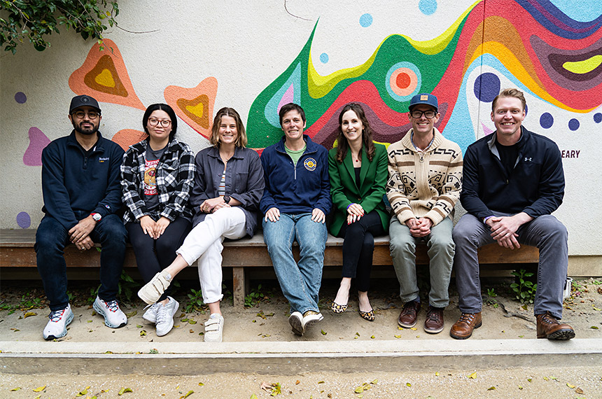 Group posed in front of mural: Evan Jester 