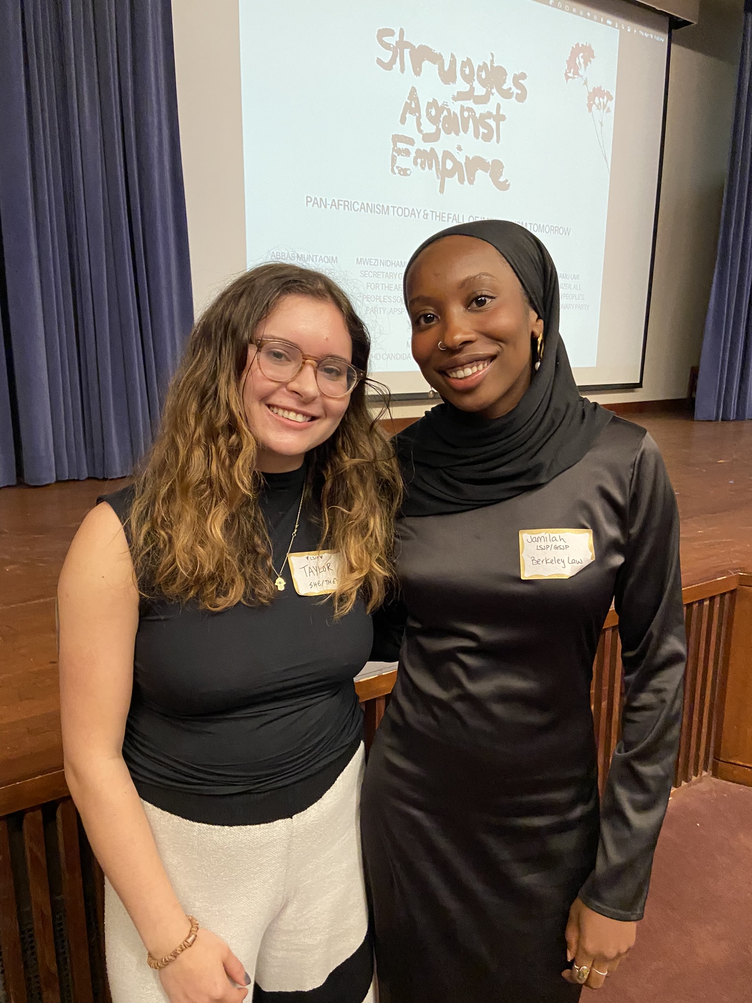 Class of 2024 Public Interest Scholars Taylor and Jamilah smile at a symposium they planned called Struggles Against Empire.