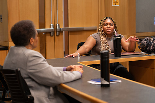 Metyia Phillips and Justice Evans in discussion at a table