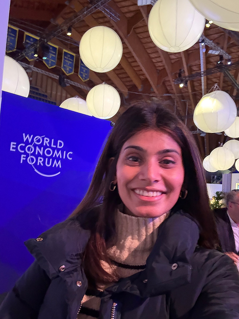 Angeli Patel standing next to World Economic Forum sign in Davos